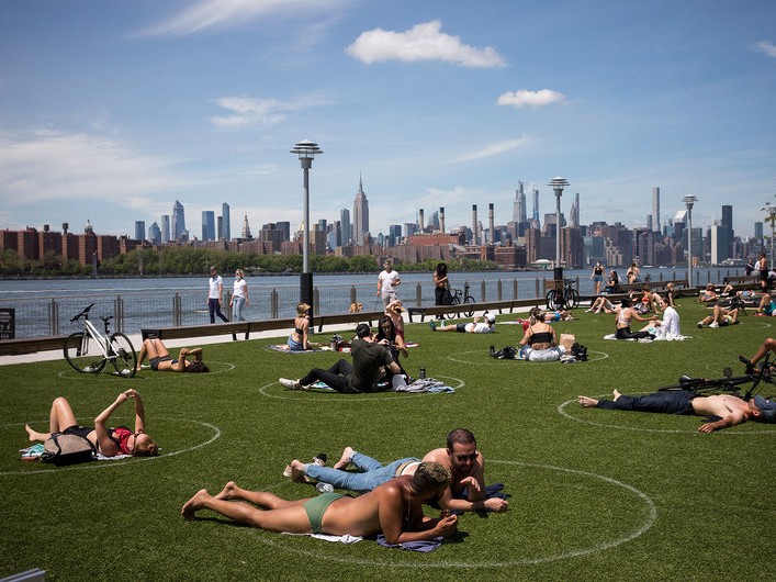 People rest inside social distancing markers at Domino Park in the Brooklyn borough of New York in late May.