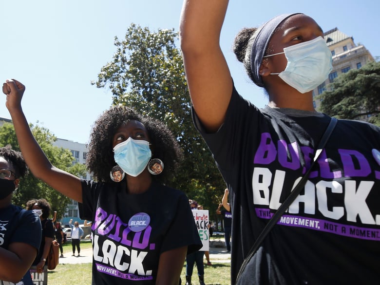 Samrawit Agezew, left, Alyssa Lomeli, wear face masks as they join others at a Juneteenth rally in Sacramento, Calif., Friday, June 19, 2020.