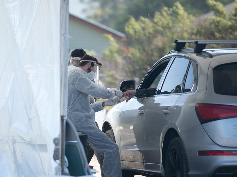 A phlebotomist takes a finger prick blood sample at a drive-through COVID-19 testing site in Bolinas on April 22, 2020. Bolinas is attempting to test the entire town in conjunction with a UCSF study, one of the first efforts of its kind in California