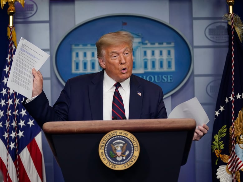 President Donald Trump holds articles as he speaks during a news conference at the White House, Thursday, July 30, 2020, in Washington.