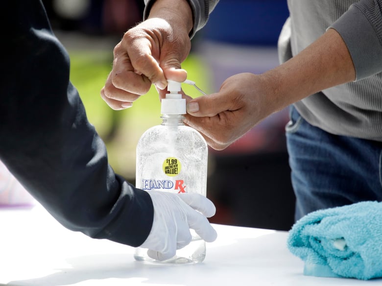 Hand sanitizer is dispensed at a mobile shower service for the homeless provided by The Shower of Hope MacArthur Park Monday, March 23, 2020, in Los Angeles.