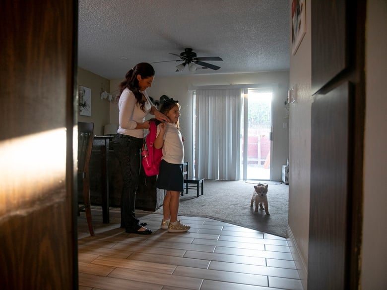 Diana Marrone helps her daughter Sienna, 5, into her backpack at their Oakley home before leaving for school on Sept. 22, 2020. Marrone, who works full time, enrolled Sienna in a private Christian school so she would have in-person instruction.
