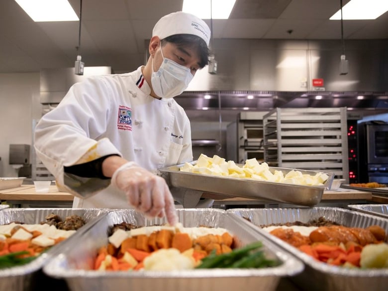 Advanced cuisine student Soon Gi Hwang places butter pats into trays of prepared thanksgiving dinners which will be frozen and distributed through the campus food pantry at Diablo Valley College on Nov. 18, 2020.