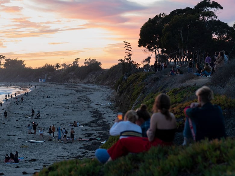 People gather near the cliffs as the sun sets in Isla Vista, a student neighborhood near the University of California Santa Barbara, on Dec. 8 2020.