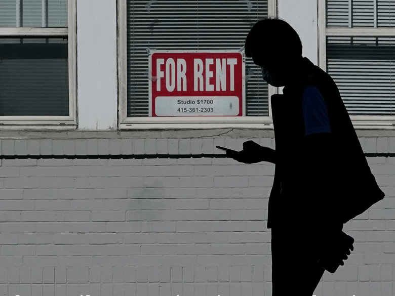 A man walks in front of a For Rent sign in a window of a residential property in San Francisco, Tuesday, Oct. 20, 2020.