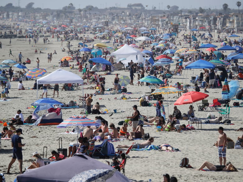 In this May 24, 2020, file photo, visitors gather on the beach during the Memorial Day weekend in Newport Beach, Calif. California's mood has gone from optimistic to sour as coronavirus cases and hospitalizations are on the rise.