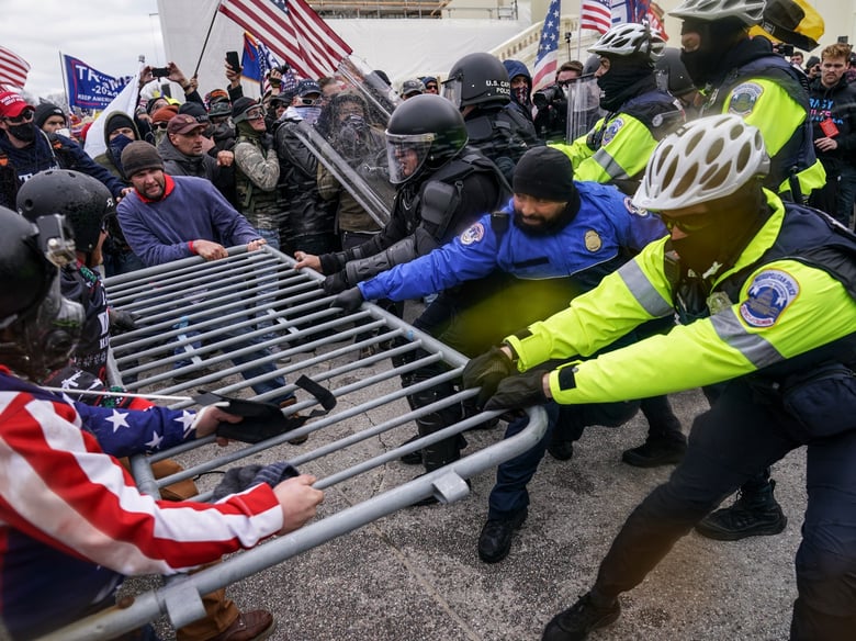 Trump supporters try to break through a police barrier, Wednesday, Jan. 6, 2021, at the Capitol in Washington.