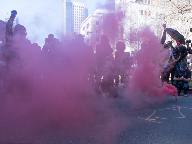 Individuals dressed in nearly all black, associated with the antifa and block movements march near the California state Capitol building downtown Sacramento Jan. 20, 2021.