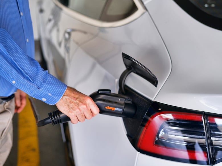 In this Oct. 16. 2019, file photo a driver plugs in the Charge Point electric plug into his Tesla car at a parking garage in downtown Los Angeles.