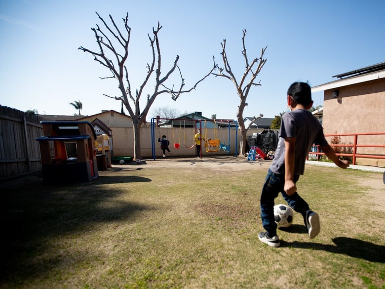 Children play in the backyard of Ana Ballestero's home where she runs a day care in Delano on Feb. 26, 2021.