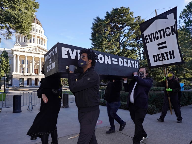 Demonstrators calling for lawmakers and Gov. Gavin Newsom to pass rent forgiveness and stronger eviction protections carry a mock casket past the state Capitol in Sacramento on Jan. 25, 2021.