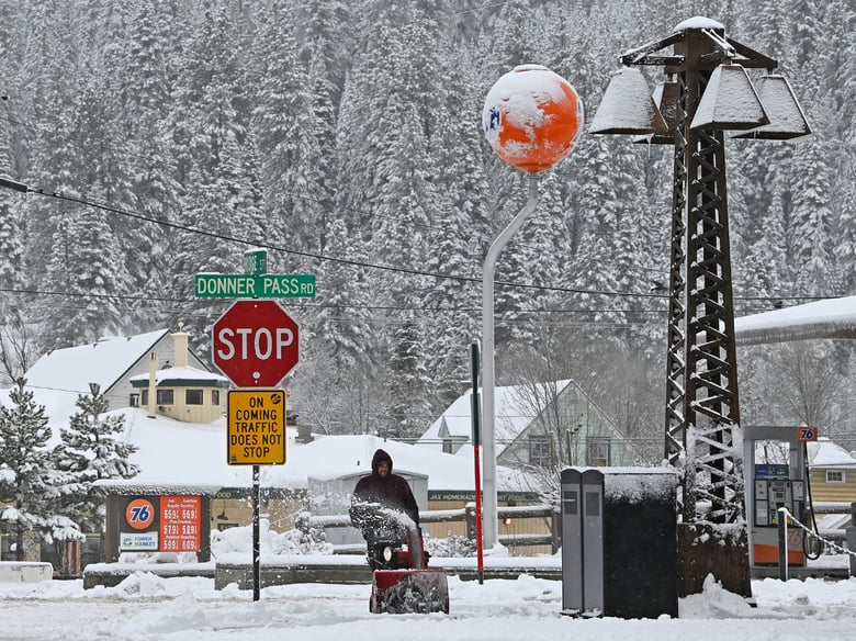 Juan Manuel plows the snow off the sidewalk in front of The Bar of American where he is employed on Friday, March 1, 2024, in downtown Truckee, Calif.