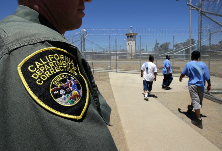 Inmates pass a Correctional Officer as they leave an exercise yard at the California Medical Facility in Vacaville, Calif. On Friday, Sept. 30, 2022.