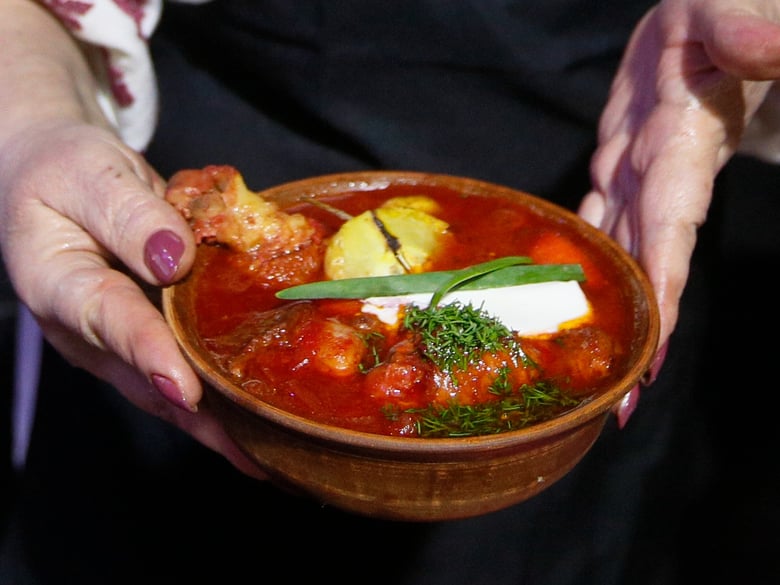 A woman holds borscht in Kyiv, Ukraine, Friday, March 5, 2021.