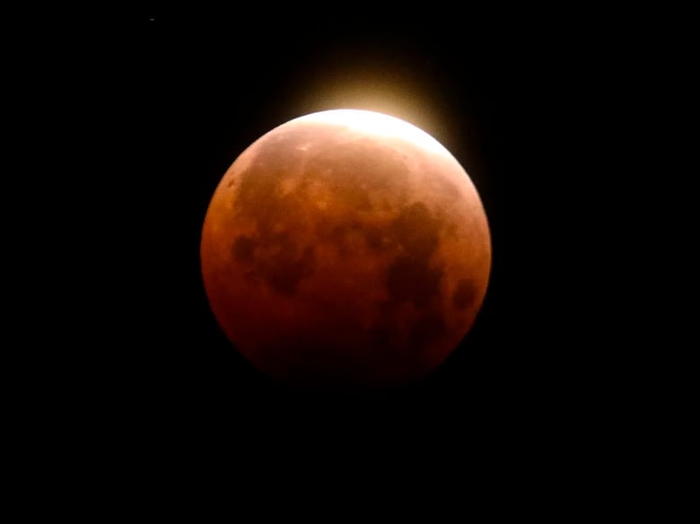 Light shines from a total lunar eclipse over Santa Monica Beach in California in 2021.