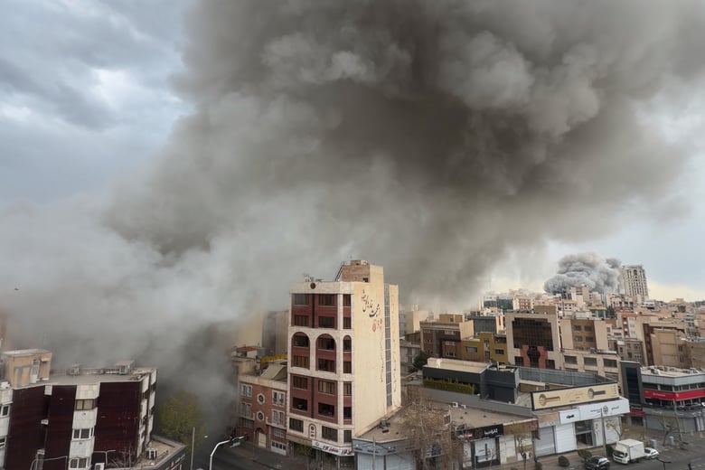 Plumes of smoke from two simultaneous strikes rise over Tehran, Iran, Monday, March 2, 2026. (AP Photo/Mohsen Ganji)