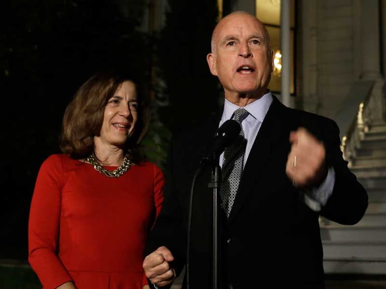 Gov. Jerry Brown, right, accompanied by wife Anne Gust Brown, talks to reporters outside the Old Governors Mansion State Historic Park after winning re-election Tuesday, Nov. 4, 2014, in Sacramento, Calif. 