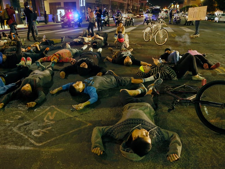 Protesters lay down on a street, Rodeo Drive, Beverly Hills, in Los Angeles, Calf., Tuesday, Nov. 25, 2014.