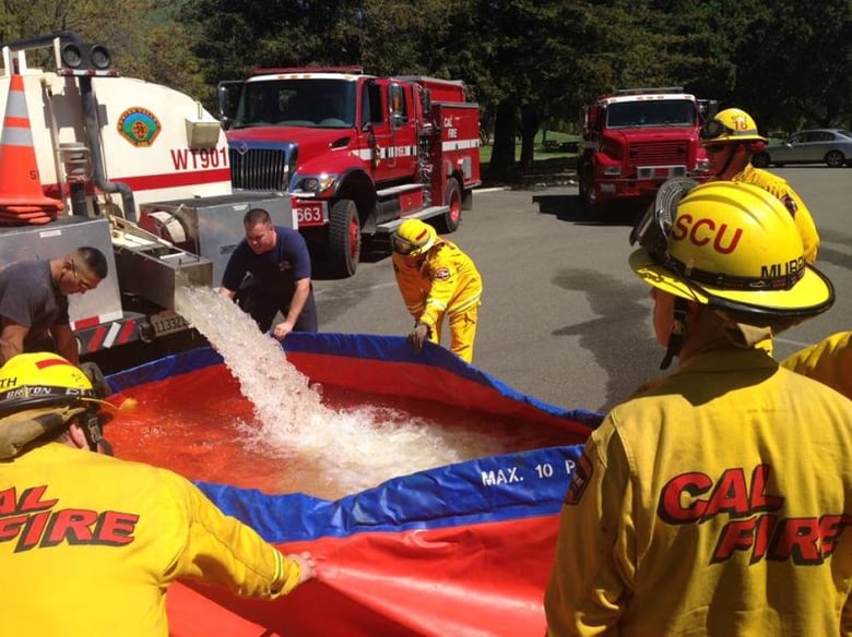 CAL FIRE Firefighters practice filling an inflatable pool used for firefighting in rural areas.


