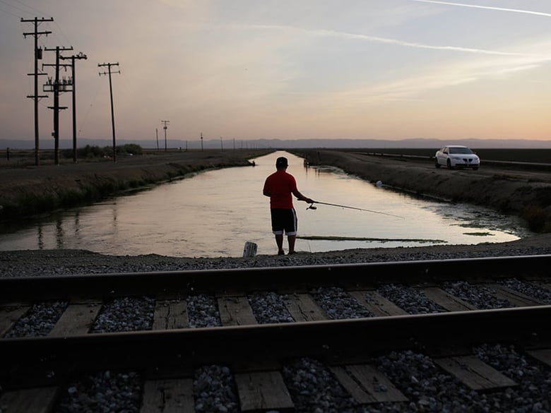 In this May 3, 2014 file photo, Rigoberto Arroyo, 18, fishes from a canal in Mendota, Calif. 