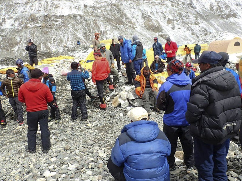 In this photo provided by Azim Afif, people are examined for injuries and prepared for helicopter evacuation at the International Mount Guide (IMG) camp at Everest Base Camp, Nepal on Sunday, April 26, 2015.