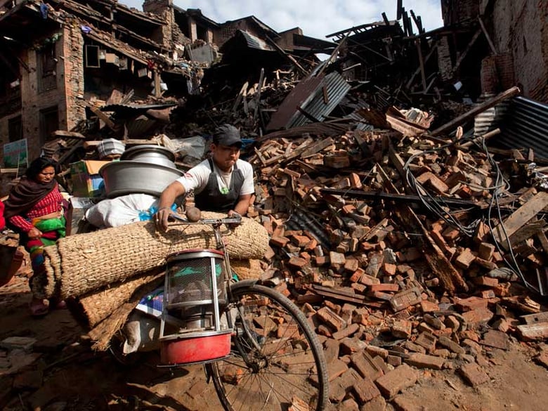 People walk past damage caused by Saturday's earthquake in Bhaktapur, on the outskirts of Kathmandu, Nepal, Monday, April 27, 2015.