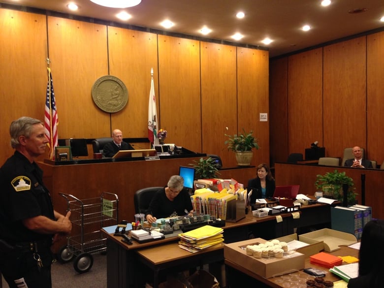 Judge Larry Brown presides over Mental Health Court in Sacramento County. Cupcakes for participants are on the table in front of them.