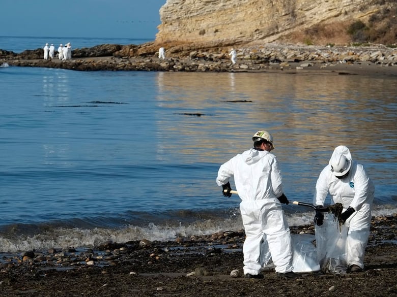 Clean up workers place shovels of oil-laden sand in bags while a larger group of workers begin clean up operations at Refugio State Beach, site of an oil spill, north of Goleta, Calif., Wednesday, May 20, 2015.