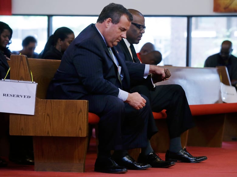 New Jersey Gov. Chris Christie, left, and Dwayne D. Warren, Mayor of Orange, N.J., hold hands during a service at St. Matthew African Methodist Episcopal Church Sunday, June 21, 2015, in Orange, N.J. 