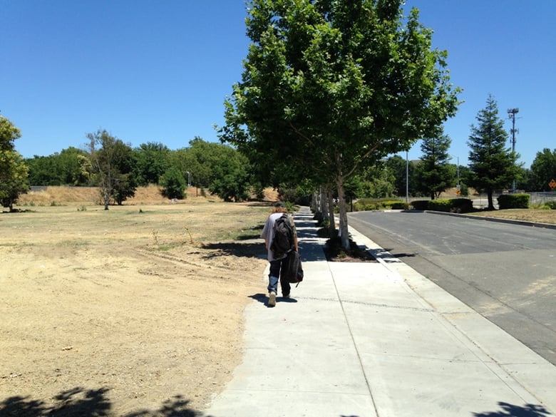 A homeless man walks across the entryway to what was the Old Town Inn in West Sacramento. The inn served as temporary shelter for some of the area's homeless under a pilot program before the hotel was torn down.
