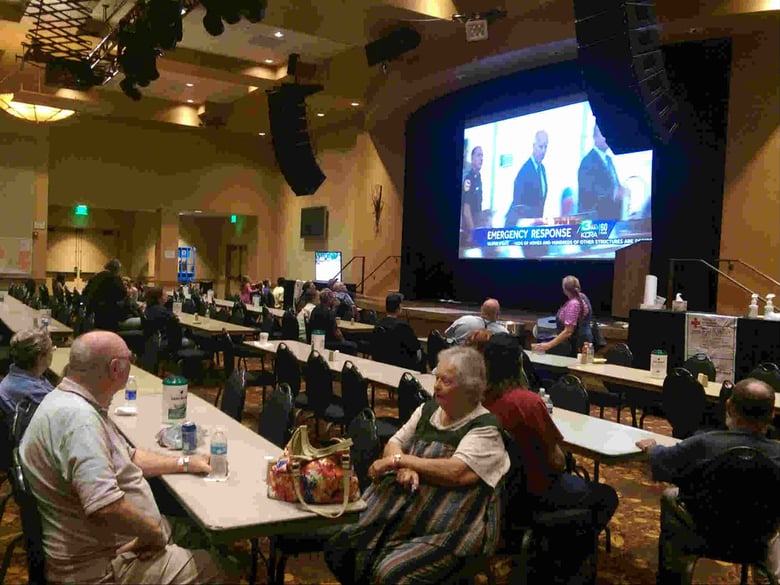 Residents who were evacuated from their homes due to the Butte Fire in Amador and Calaveras counties watch a television news report Sept. 14, 2015 about Gov. Jerry Brown's press conference earlier in the day.