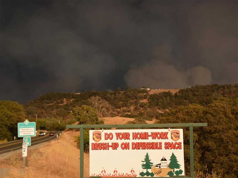 A message from Cal Fire, with the Butte Fire burning in the distance on Saturday, Sept. 12, 2015.