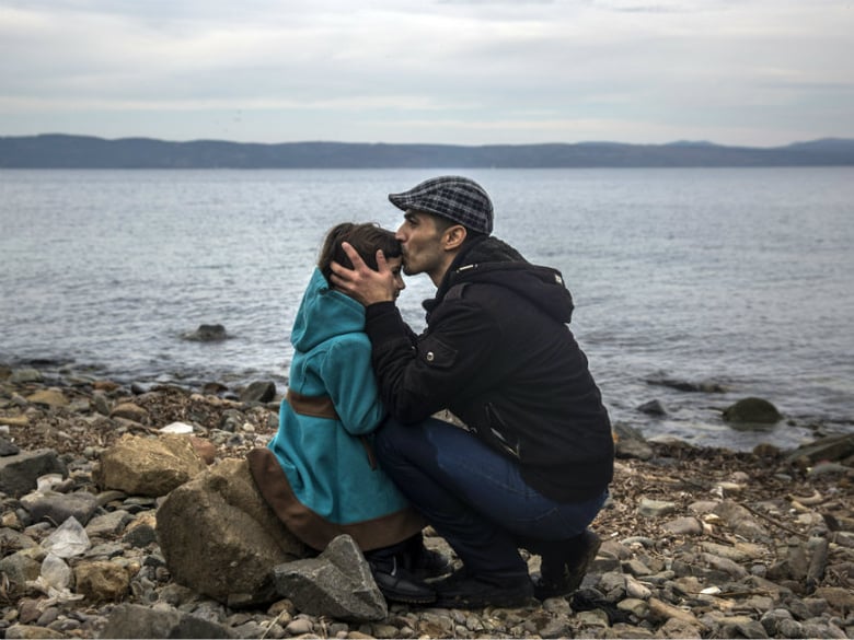 A Syrian man kisses his daughter shortly after disembarking from a dinghy at a beach on the Greek island of Lesbos after crossing the Aegean sea from the Turkish coast, Monday, Nov. 16, 2015.