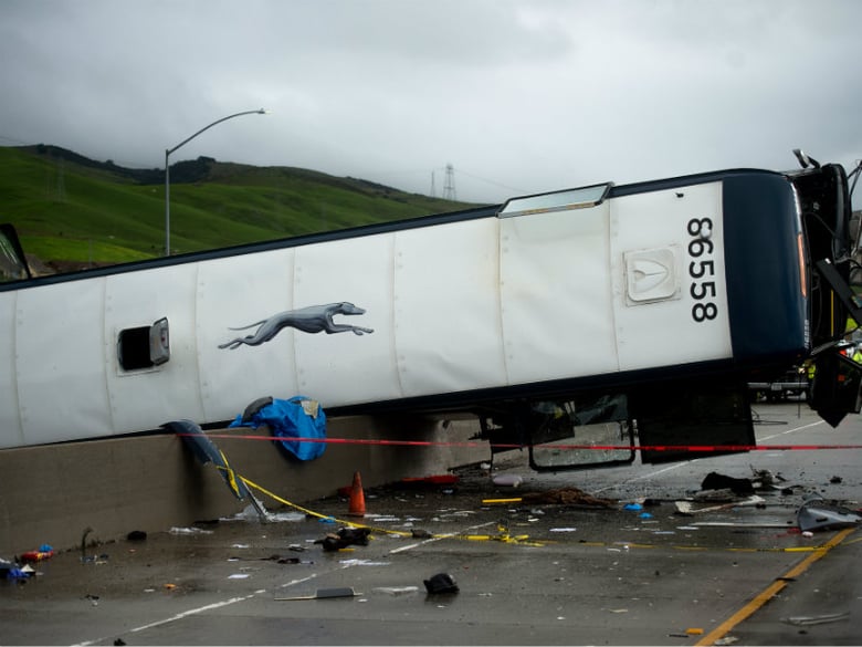An overturned Greyhound bus rests atop a Highway 101 divider following a crash on Tuesday, Jan. 19, 2016, in San Jose, Calif. A Greyhound bus carrying 20 passengers rolled onto its side during a rainy Tuesday morning commute, killing at least two.