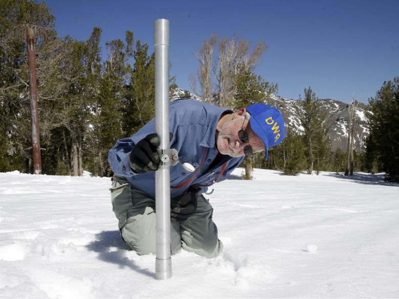 In this April 28, 2015 file photo, Frank Gehrke, chief of the California Cooperative Snow Surveys Program for the Department of Water Resources, checks the  snowpack depth during a snow survey at Leavitt Lake near Bridgeport Calif.