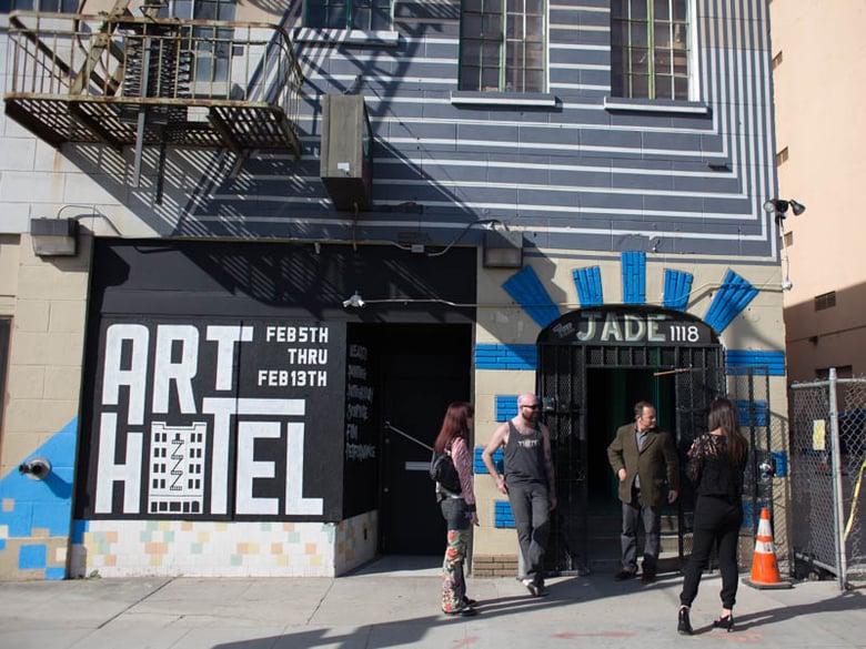 Artist Chris Hopkins (left) leans against the entrance to the "Art Hotel," the show's curator, Seamas Coutts, looks down the street on Feb. 5, opening day of the temporary art installation. 
