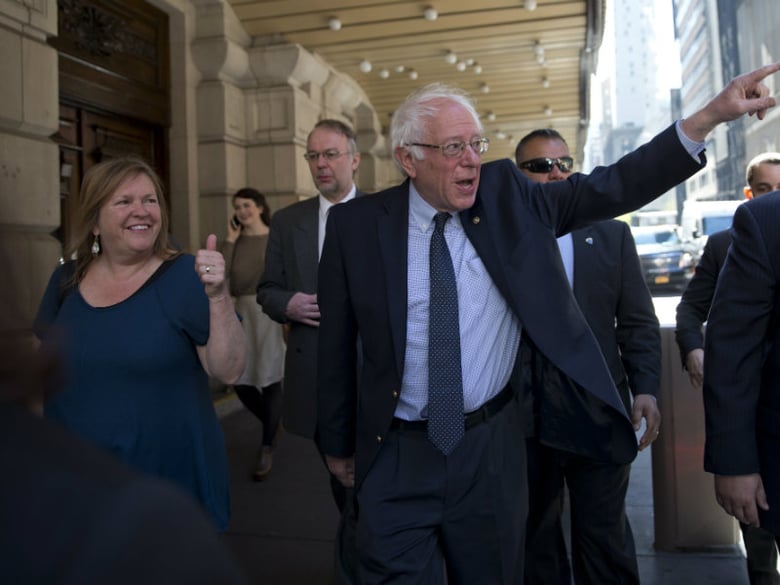Democratic presidential candidate Sen. Bernie Sanders, I-Vt., and his wife Jane, gesture at supporters as they take a walk in New York's Times Square, Tuesday, April 19, 2016. (AP Photo/Mary Altaffer)
