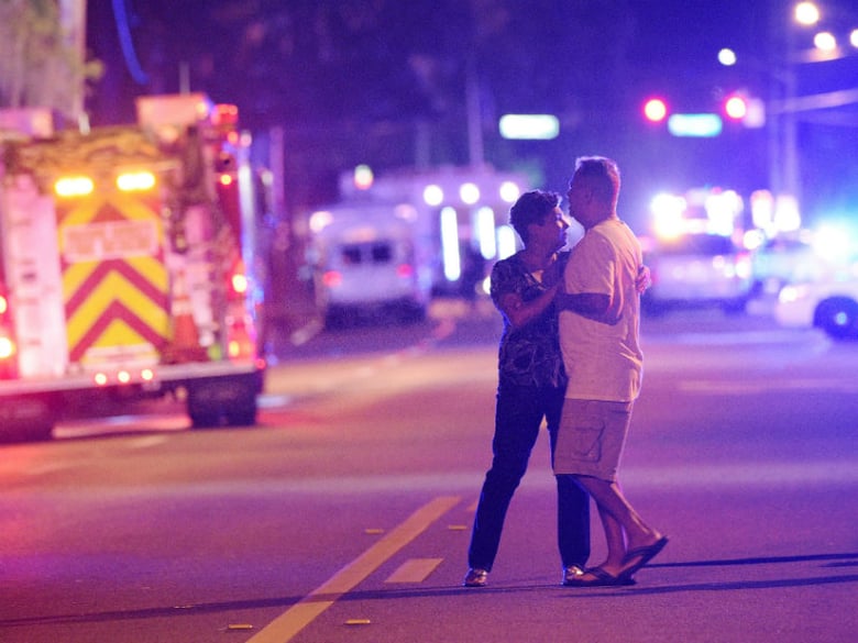 Family members wait for word from police after arriving down the street from a shooting involving multiple fatalities at Pulse Orlando nightclub in Orlando, Fla., Sunday, June 12, 2016. 