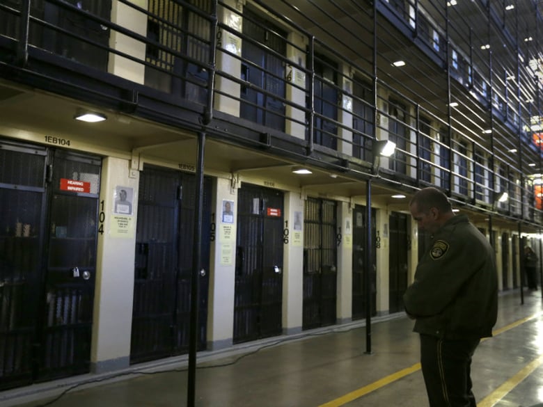 File: In this photo taken on Tuesday, Dec. 29, 2015, a guard stands watch over condemned inmates on death row at San Quentin State Prison in San Quentin, Calif. 
