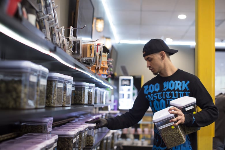 Budtender Andrew Urbina pulls strains from a shelf for a patient at Kushmart, one of the largest medical marijuana dispensaries in downtown Los Angeles, on Monday afternoon, Feb. 29, 2016.