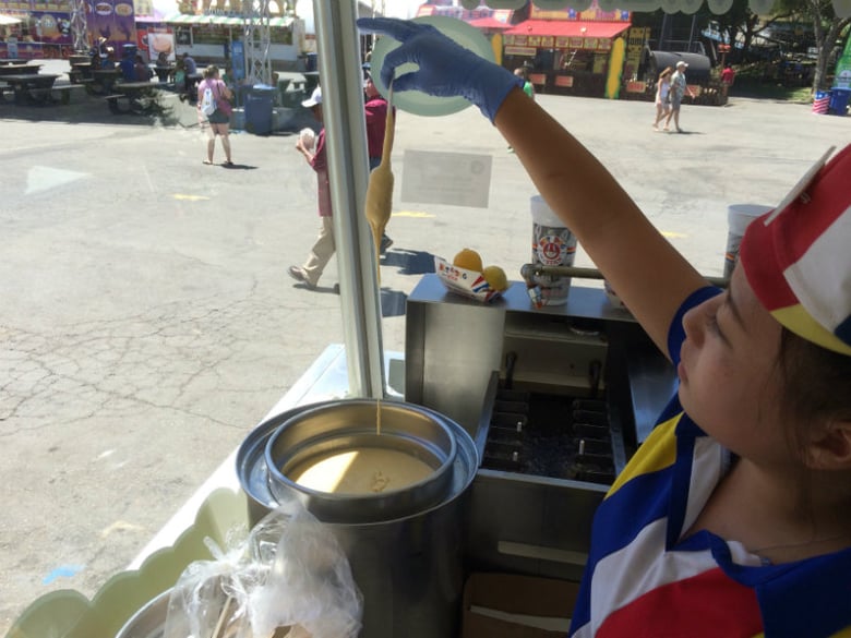 Kristy Vang dips a mini corn dog on "$2 Taste of the Fair" Thursday at the 2016 California State Fair.