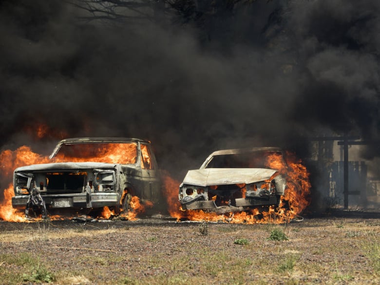 Cars burn in the town of Lower Lake, Calif., on Sunday, Aug. 14, 2016. Flames continue to burn out of control in the area. 