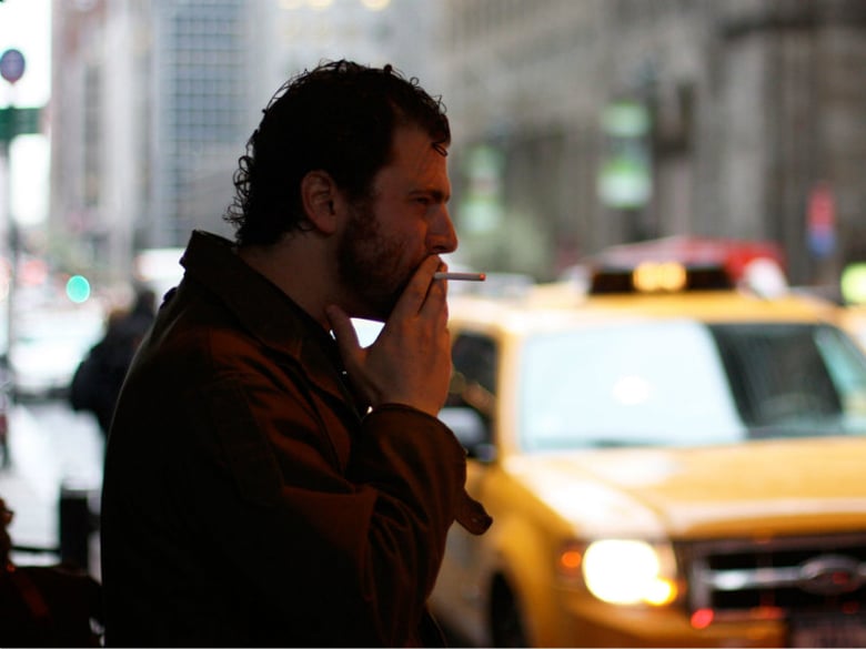 A man smokes a cigarette in New York City, where the current tobacco tax is $4.35 a pack. 
