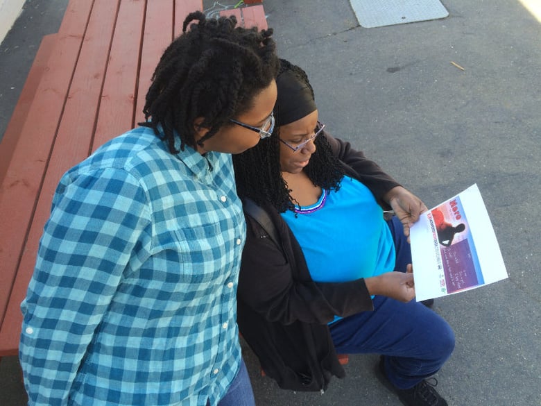 Syria Harris and her mother look at a copy of a placard that contains her poetry, which will be displayed in Regional Transit buses. 