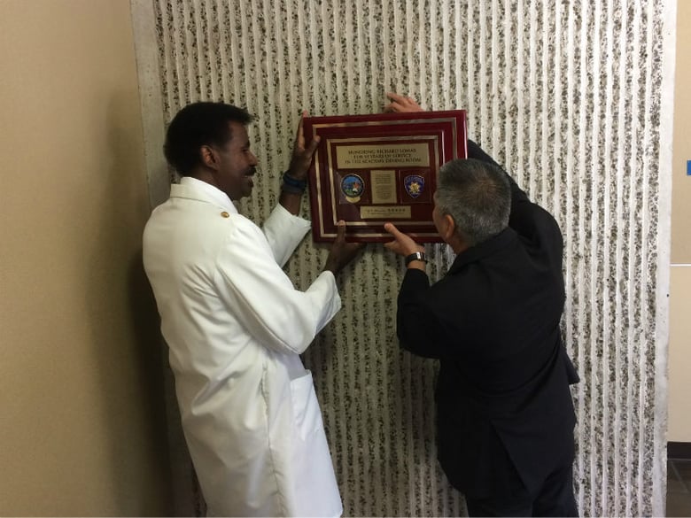 CHP Senior Volunteer Richard Lomax and CHP Commissioner Joseph Farrow hang a plaque commemorating Lomax' 50 years of service with the department. 