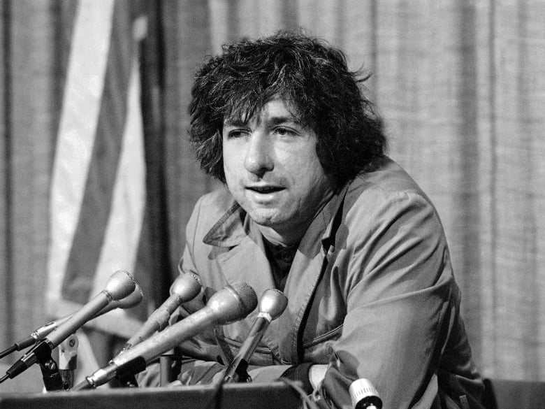 FILE - In this Dec. 6, 1973 file photo, political activist Tom Hayden tells newsmen in Los Angeles that he believes public support was partially responsible for the decision not to send him and others of the Chicago 7 to jail for contempt. 