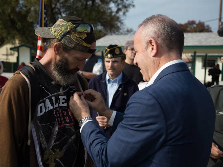 Army veteran Richard Dean accepts an American flag pin from Mayor-elect Darrell Steinberg during a ceremony honoring Dean and other homeless veterans at Loaves and Fishes on Friday, Nov. 11.