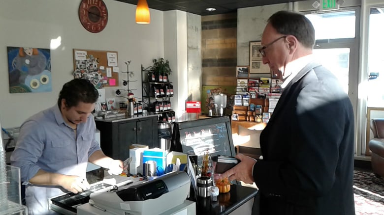 Two people helping the Turnaround Coffee House's mission: intern/college student Juan Bruno volunteers his time behind the counter and Tim Ainsworth brings much-needed business through the shop's 7th Street doors.