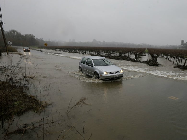 A car drives through flooded water on Green Valley Road in Graton, Calif., Saturday, Jan. 7, 2017. 
