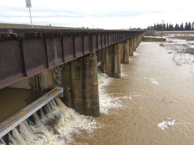 A photo of the Sacramento Weir on the morning of Jan. 9, 2017 with water splashing through.